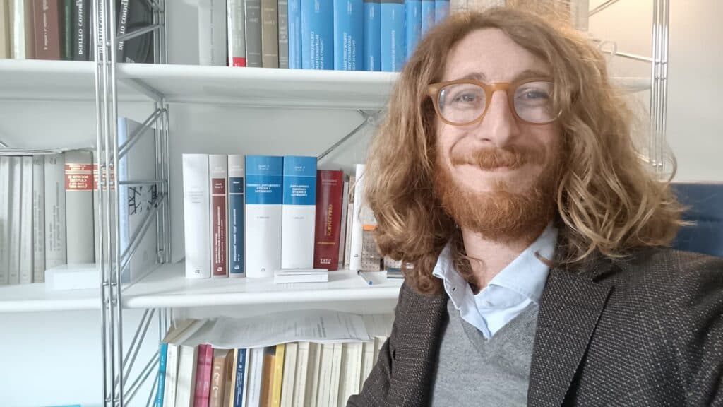 Il notaio Gabriele Scaglia davanti a una libreria di codici